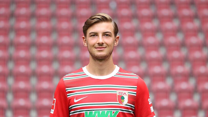 Lukas Petkov steht beim Mannschaftsfototermin des FC Augsburg in der WWK-Arena.