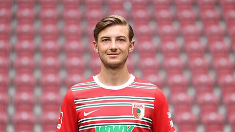 Lukas Petkov steht beim Mannschaftsfototermin des FC Augsburg in der WWK-Arena.