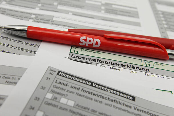 Auf einem Schreibtisch liegt ein Mantelbogen zur Erbschaftsteuererklärung. Darauf liegt ein Kugelschreiber der Partei SPD. Mit ihrem Reformkonzept für die Erbschaftsteuer beißen die Sozialdemokraten beim Koalitionspartner CDU bisher auf Granit. Auf einem Schreibtisch liegt ein Mantelbogen zur Erbschaftsteuererklärung. Darauf liegt ein Kugelschreiber der Partei SPD. Mit ihrem Reformkonzept für die Erbschaftsteuer beißen die Sozialdemokraten beim Koalitionspartner CDU bisher auf Granit.