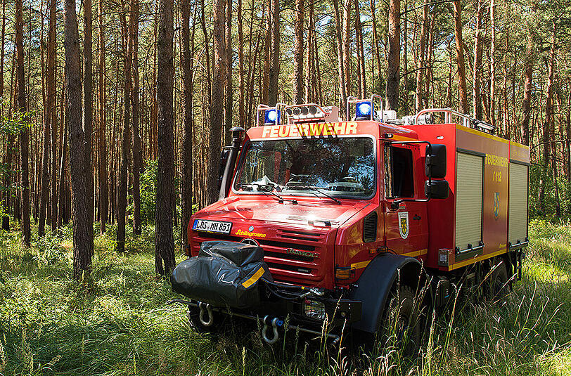 Ein Einsatzfahrzeug der Feuerwehr steht am Rand eines Kiefernwaldes in Brückchen nahen Lübben. In diesem Forst wurde zuvor ein kleiner Waldbrand gelöscht.