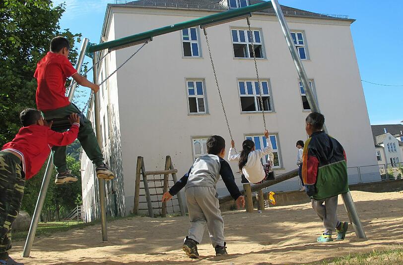 Kinder schaukeln auf einem Spielplatz.