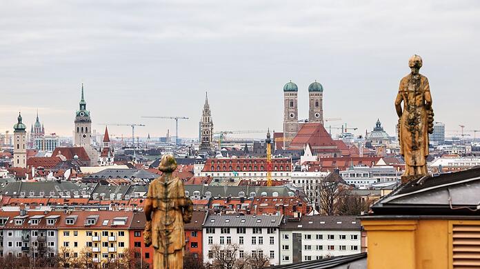 Die Figuren auf dem Landtagsdach sind vor der Altstadt von München mit dem Alten Peter, dem Rathaus und der Frauenkirche zu sehen.