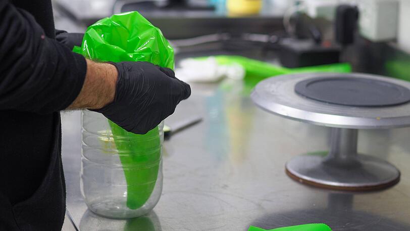 Über eine abgeschnittene Plastikflasche lässt sich der Spritzbeutel ganz einfach überstülpen. Über eine abgeschnittene Plastikflasche lässt sich der Spritzbeutel ganz einfach überstülpen.