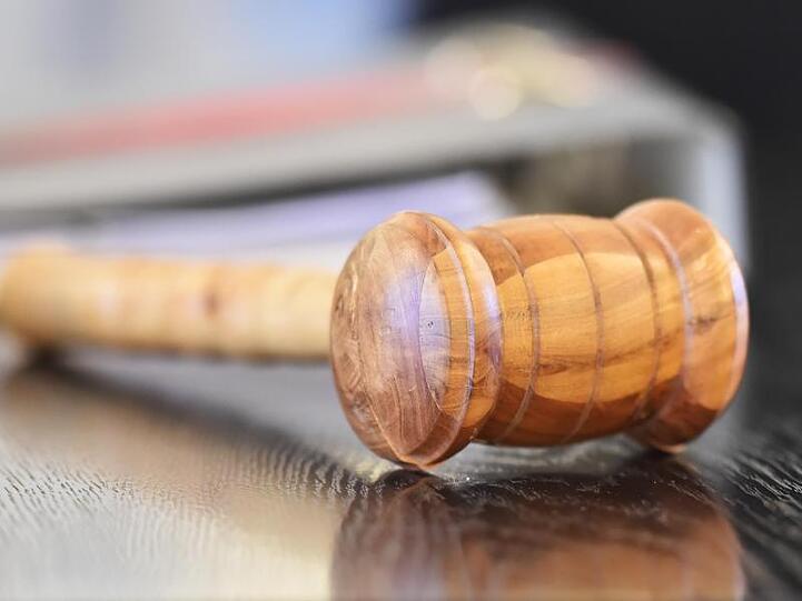 Ein Richterhammer aus Holz liegt auf der Richterbank. Foto: Uli Deck/dpa
