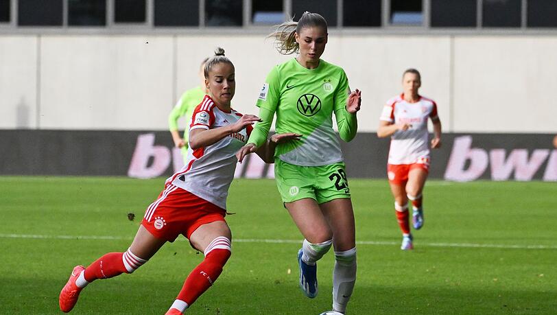 Bayerns Giulia Gwinn (l) kämpft mit Wolfsburgs Jule Brand um den Ball.