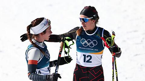 Darija Neprjajeva (l) nahm w&auml;hrend des Olympia-Rennens versehentlich die Ski von Katharina Hennig Dotzler.