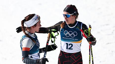Darija Neprjajeva (l) nahm w&auml;hrend des Olympia-Rennens versehentlich die Ski von Katharina Hennig Dotzler.