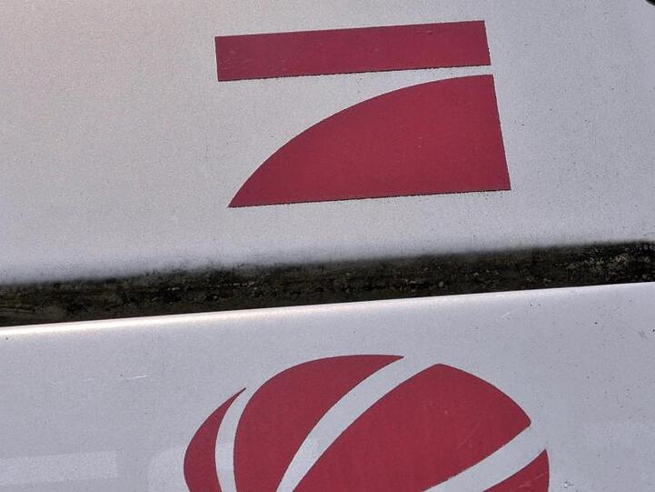 Die Logos der Medienanstalten ProSiebenSat.1 Media AG, ProSieben und SAT.1 erscheinen als Wegweiser. Foto: picture alliance / dpa/Archivbild