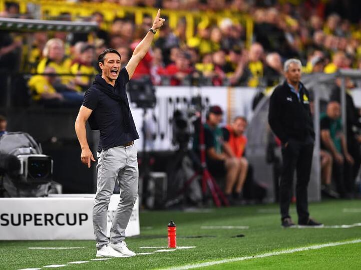 Dortmunds Trainer Lucien Favre (r) und Bayerns Trainer Niko Kovac stehen an der Seitenlinie.