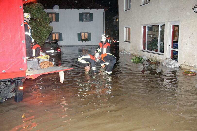 Die Feuerwehr arbeitet am Sonntag an einer überfluteten Strasse in Zell (Unterallgäu). Nach einem schweren Gewitter mit Hagel, Sturm und Starkregen sind zahlreiche Keller im Unterallgäu mit Wasser voll
