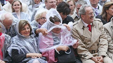 Am Odeonsplatz erschien Christian Ude stilsicher im Trenchcoat. Seine Gattin Edith von Welser sowie Charlotte Knobloch und Edmund Stoiber (v. r.) behalfen sich mit Plastik-Pelerinen.