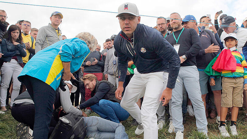 Der Moment des Unglücks: Brooks Koepka (Mitte) hat bei einem Schlag beim Ryder Cup eine Zuschauerin mit seinem Golfball getroffen. Der Moment des Unglücks: Brooks Koepka (Mitte) hat bei einem Schlag beim Ryder Cup eine Zuschauerin mit seinem Golfball getroffen.
