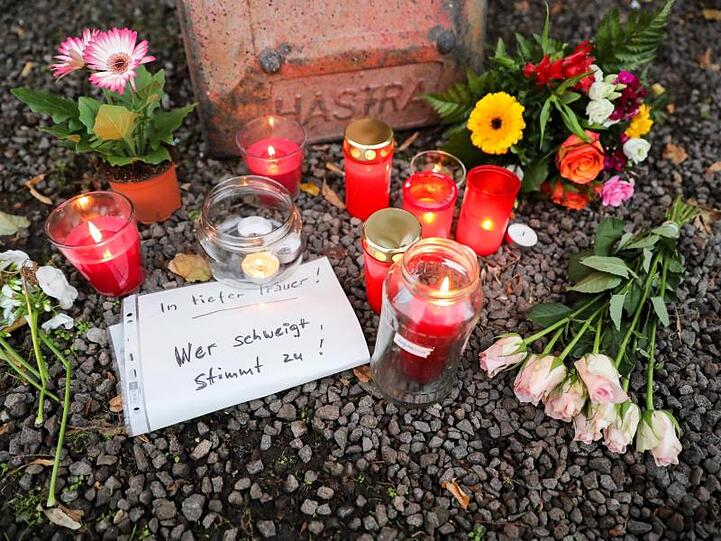 Kerzen, Blumen und ein Zettel mit der Aufschrift "In tiefer Trauer Wer schweigt stimmt zu!" vor einem Dönerladen. Foto: Jan Woitas/dpa-Zentralbild/dpa