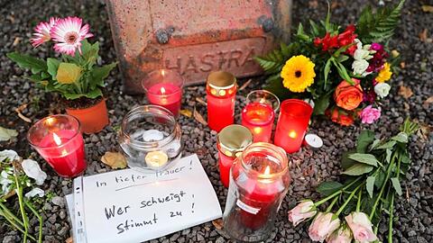 Kerzen, Blumen und ein Zettel mit der Aufschrift "In tiefer Trauer Wer schweigt stimmt zu!" vor einem Dönerladen. Foto: Jan Woitas/dpa-Zentralbild/dpa