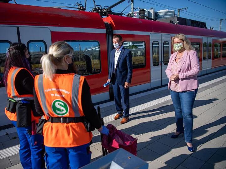 Verkehrsministerin Schreyer (r, CSU) redet mit S-Bahn Mitarbeitern. Hinten (l) steht der Bayern-Beauftragte der Bahn, K.D. Josel. Foto: Lino Mirgeler/dpa/Archivbild