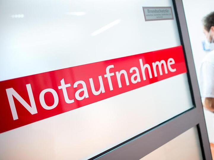 Ein Krankenpfleger geht in einem Klinikum durch eine Glastür mit der Aufschrift "Notaufnahme". Foto: Hauke-Christian Dittrich/Archivbild