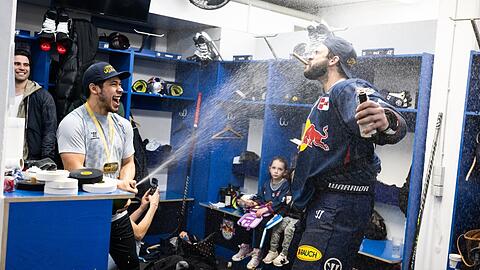 Münchner Feierbiester: EHC-Ass Austin Ortega (l.) "löscht" per Champagner-Dusche die Meister-Zigarre von Trevor Parkes.