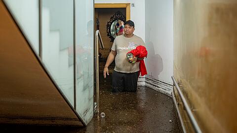 Ein Mann steht im Treppenhaus eines Geb&auml;udes in der an Barcelona grenzenden Stadt L'Hospitalet de Llobregat in mehr als knietiefem Wasser.