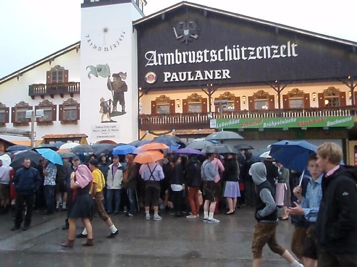 Trotz Sauwetter und Regen warten bereits viele Wiesngänger auf den Wiesnanstich. Der Kampf um den Platz im Bierzelt beginnt schon am frühen Morgen. Die ersten Bilder.