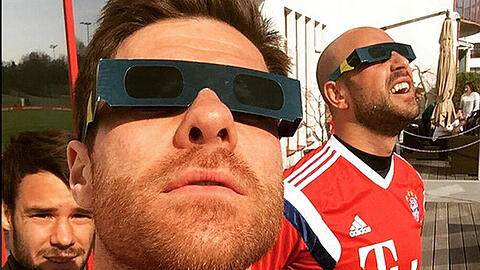 FC Bayern-Star Xabi Alonso (vorne) beobachtet mit Kollegen die Sonnenfinsternis