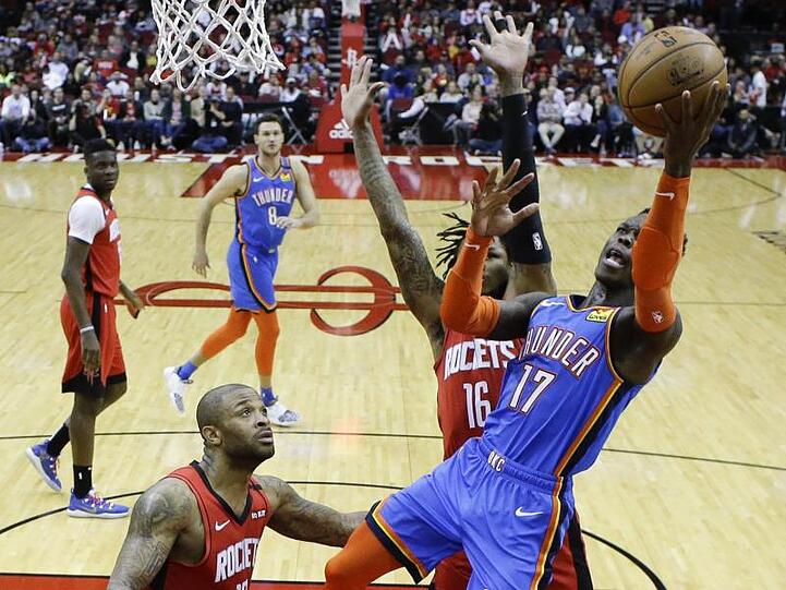 Dennis Schröder (r/17) von den Oklahoma City Thunder setzt sich am Korb gegen Ben McLemore (M) von den Houston Rockets durch.