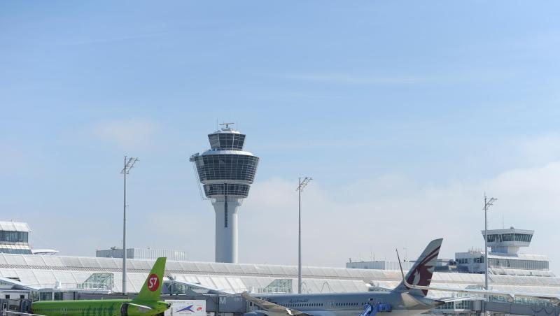 Mehrere Flugzeuge stehen auf dem Flughafen an einem Terminal vor dem Tower. Mehrere Flugzeuge stehen auf dem Flughafen an einem Terminal vor dem Tower.