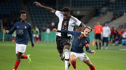Starker Zweikampf: Deutschlands Yann Aurel Bisseck (M) und Frankreichs Maxence Caqueret (r) kämpfen um den Ball.