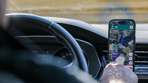 So ist es derzeit erlaubt: Das Handy steckt in der Halterung und wird nur kurz vom Fahrer beachtet. (Symbolbild)