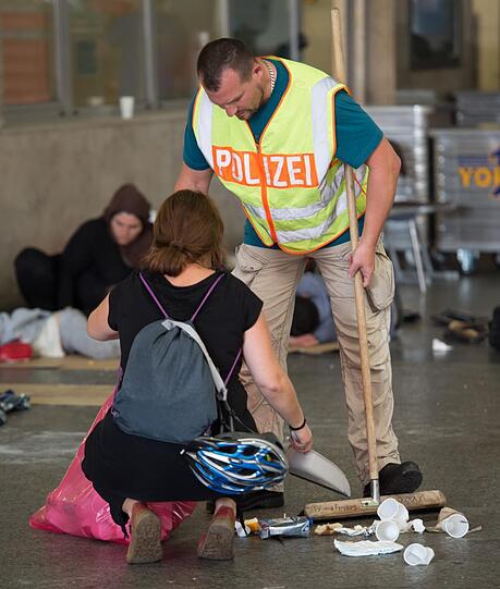 Vereint geht&rsquo;s besser: Ein Polizist und eine Freiwillige räumen auf.