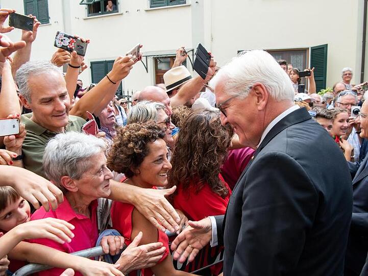 Bundespräsident Frank-Walter Steinmeier geht nach einer Kranzniederlegung fur die Opfer des Massakers von Fivizzano durch den Ort und begrüßt Besucher.