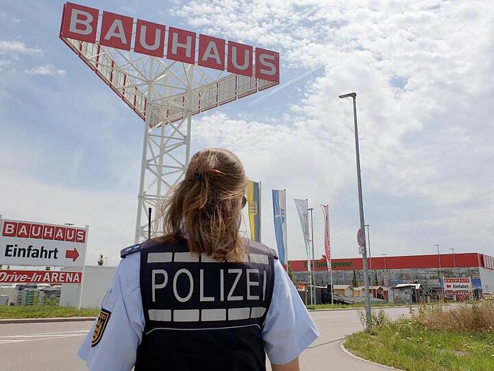 Eine Polizistin steht vor dem Baumarkt, auf dessen Gelände das Kleinflugzeug abstürzte.