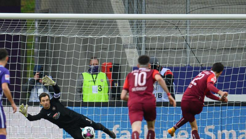 Regensburgs Sebastian Stolze (r) erzielt gegen Aues Torwart Martin Männel (2.v.l) das Tor zum 0:2.