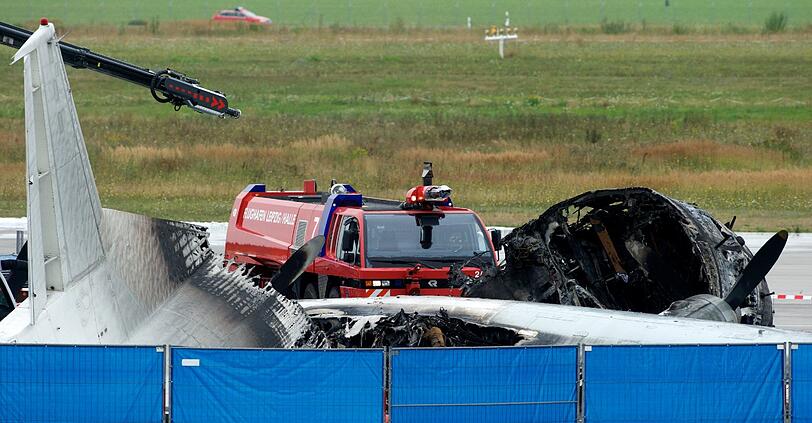 Einsatzkräfte der Feuerwehr und des Flughafens Leipzig/Halle sichern am 09.08.2013 im Frachtbereich des Flughafens in Schkeuditz (Sachsen) eine ausgebrannte Frachtmaschine.