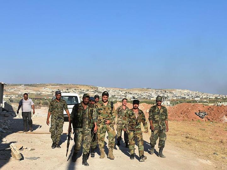 Syrische Soldaten gehen durch die Stadt Chan Schaichun.