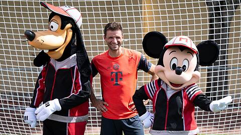 Thomas Müller mit Goofy und Micky Maus.