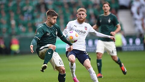 Bremens Romano Schmid (l) behauptet den Ball gegen Heidenheims Jan-Niklas Beste.