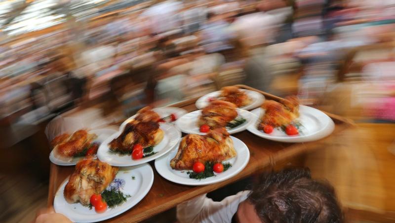 Diät geht anders: Kellner auf dem Oktoberfest mit einem Tablett Hendl (Hähnchen). Diät geht anders: Kellner auf dem Oktoberfest mit einem Tablett Hendl (Hähnchen).