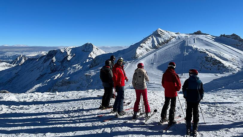 Wintersportler schauen auf ein Skigebiet.