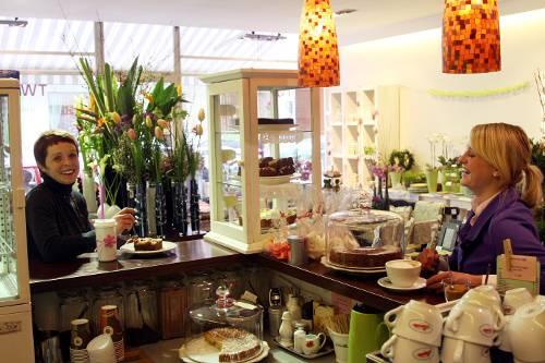 Bei der Apfel-Birnen-Schmandtorte wird auch die Chefin selbst immer wieder mal schwach: Claudia Nothhaas (l.) in ihrer nach Blumen und Kaffee duftenden Geschenke-Boutique.