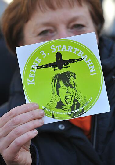 Teilnehmer einer Demonstration gegen den Bau der dritten Startbahn am Münchner Flughafen halten am Samstag auf dem Marienplatz in München Plakate in die Höhe.