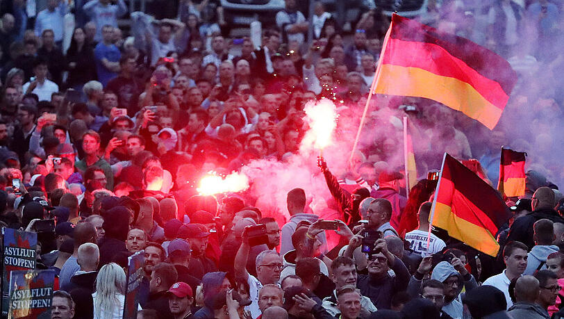 Chemnitz im August: Demonstranten der rechten Szene zünden Pyrotechnik und schwenken Deutschlandfahnen. Chemnitz im August: Demonstranten der rechten Szene zünden Pyrotechnik und schwenken Deutschlandfahnen.