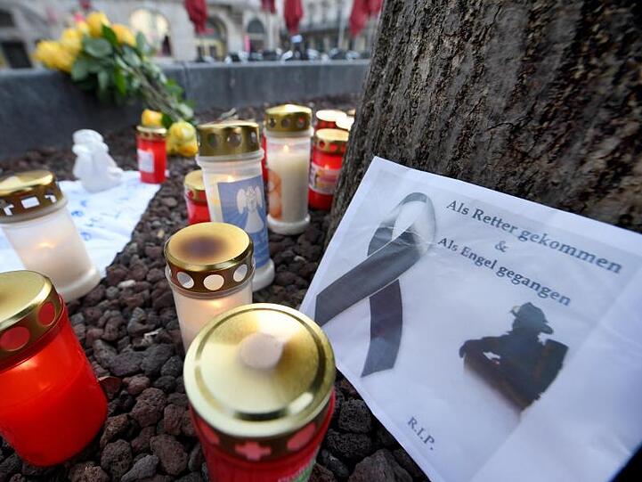 Blumen und Kerzen zum Gedenken an den getöteten Feuerwehrmann am Königsplatz in Augsburg. Foto: Stefan Puchner/dpa