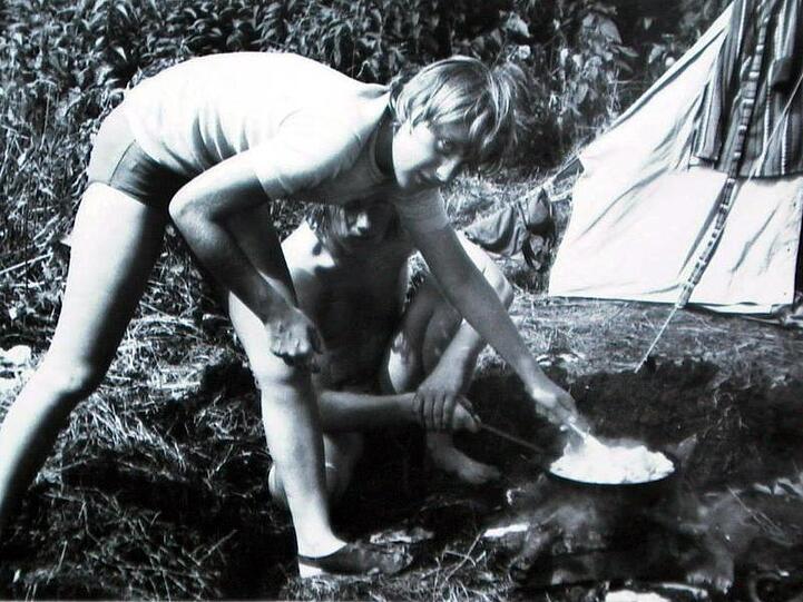 Angela Kasner bereitet im Juli 1973, nach ihrem Abitur mit Freunden beim Camping im brandenburgischen Himmelpfort auf einer Feuerstelle ein Essen zu.