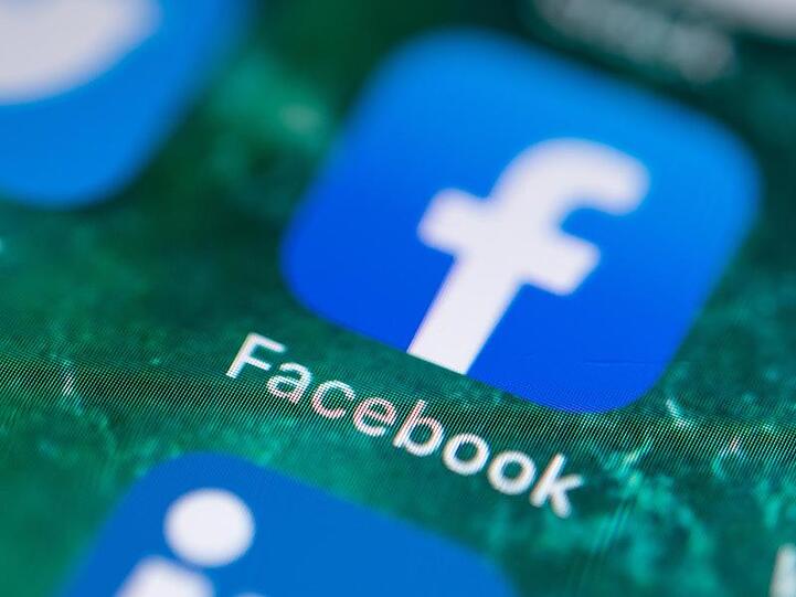 Auf dem Bildschirm eines iPhones wird die App Facebook angezeigt. Foto: Fabian Sommer/Archivbild