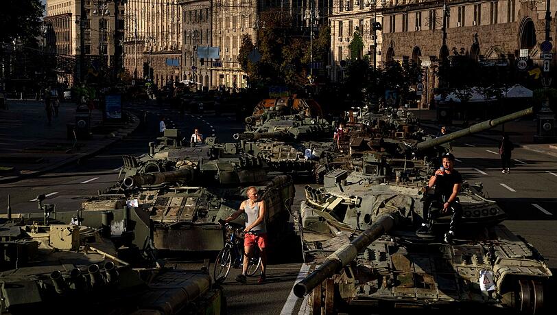 Menschen inspizieren zerstörte russische Militärfahrzeuge, die in der Innenstadt von Kiew aufgestellt sind. Menschen inspizieren zerstörte russische Militärfahrzeuge, die in der Innenstadt von Kiew aufgestellt sind.