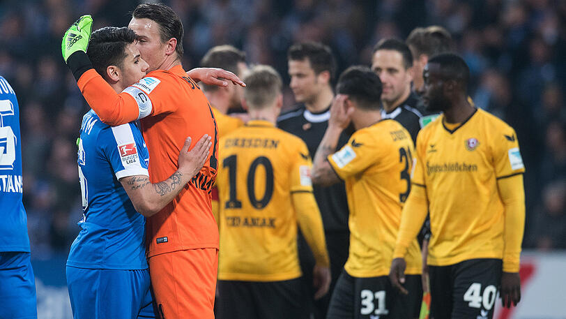 Geschafft: Die Bochumer Görkem Saglam (links) und Torhüter Manuel Riemann umarmen sich nach dem Schlusspfiff, während die Spieler von Dresden mit dem Schiedsrichtergespann diskutieren.