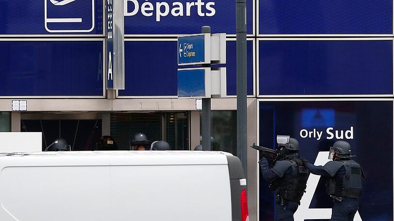 Spezialkräfte der französischen Polizei betreten mit der Waffe im Anschlag das Terminal am Flughafen.
