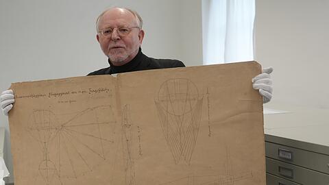 Wilhelm Füßl mit einer Zeichnung von Otto Lilienthal für ein zusammenklappbares Fluggerät.