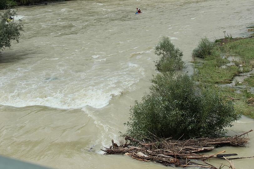 Hochwasser für die einen, perfekte Wellen für die anderen. Waghalsig tummeln sich Sportler in der Isar.