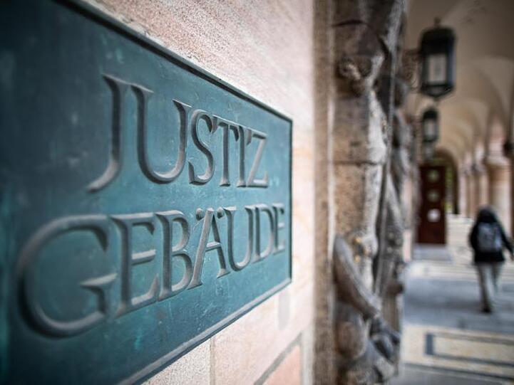 Ein Schild mit der Aufschrift "Justizgebäude" hängt am Eingang am Landgericht Nürnberg-Fürth. Foto: Daniel Karmann/dpa/Archivbild